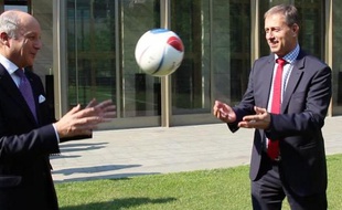 Le ministre des Affaires étrangères Laurent Fabius et l'entraîneur français de la Chine Alain Perrin lors d'une opération de promotion de l'Euro-2016 à Pékin, le 15 mai 2015