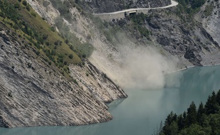 A French gendarmerie helicopter flies over a crevice formed by a landslide above the Chambon lake and the Chambon tunnel above the Chambon lake and the Chambon tunnel, on the road linking Grenoble to Briançon, by the Lautaret pass in Mont-de-Lans, near the French ski resort Les Deux Alpes, eastern France, on July 5, 2015. The road has been closed since April 10 due to tunnel damage and a risk of major landslide. The organisers of the Tour de France had to change the 20th stage of this year's race to L'Alpe dHuez as it was not possible to climb the Col du Telegraphe and the Galibier. AFP PHOTO / PHILIPPE DESMAZES