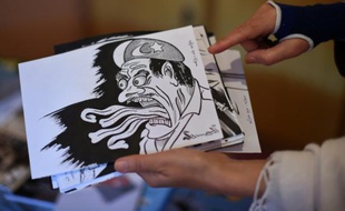 La satiriste afghane Masouda Khazan Tokhi montre une des caricatures sur laquelle elle travaille chez elle, à Kaboul, le 14 septembre 2015