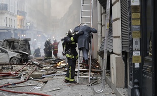 Un pompier vient en aide à une personne âgée après l'explosion due au gaz rue de Trévise (9e) à Paris, le 12 janvier 2019.