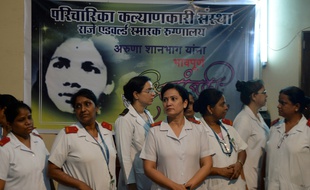 Des infirmières indiennes devant le portrait d'Aruna Shanbaug à l'hôpital de Mumbai le 18 mai 2015.AFP PHOTO/ PUNIT PARANJPE