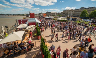 Un soleil de plomb inonde l'allée centrale de la fête.
