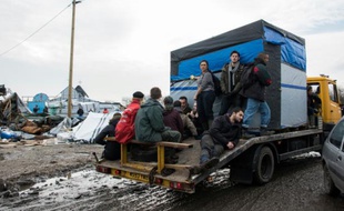 Des migrants quittent la zone sud de la "Jungle" lors de son démantèlement le 10 mars à Calais