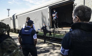 Des enquêteurs européens examinent les restes de corps de victimes du vol MH17 à Torez en Ukraine, le 21 juillet 2014