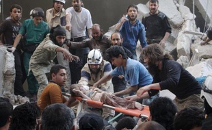 Des secouristes syriens et des habitants évacuent un enfant sur une civière après un raid aérien présumé du régime à Alep, dans le nord du pays, le 30 mai 2015