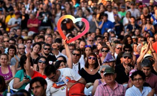 Une femme brandit un coeur lors d'un rassemblement de POdemos à Alicante le 17 juin 2016