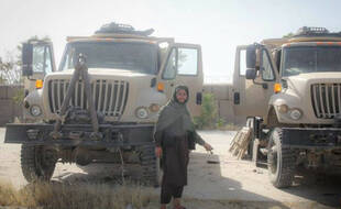 Un combattant taliban pose avec des véhicules et des équipements militaires capturés par les talibans à Gardiz le 12 août 2021.