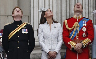 Kate Middleton, entouré des princes Harry et William, son époux, regarde la Royal Air Force survoler Buckingham Palace, le 14 juin 2014.