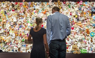 Un couple se recueille devant une "haie de la compassion" constituée de milliers de peluches à Nieuwegein, près d'Utrecht, le 17 juillet 2015, avant une cérémonie en hommage aux victimes du crash du vol MH17 de la Malaysian Airlines en Ukraine