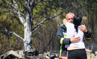 Une habitante de Bormes-les-Mimosas (Var) est réconfortée par un sapeur-pompier, ce 26 juillet 2017, alors que la commune et ses alentours étaient menacés par des incendies.