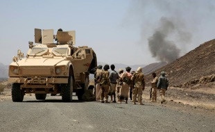 Des combattants yéménites loyalistes près d'un véhicule blindé regardent de la fumée à l'horizon, le 4 octobre 2015, dans la province de Marib, à l'est de Sanaa
