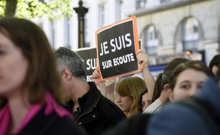 Des manifestants portent des pancartes "Je suis sur écoute" pastichant le slogan "Je suis Charlie" pour protester contre le projet de loi sur le renseignement, le 13 avril 2015 à Paris