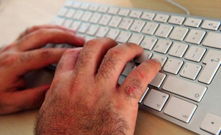 Un internaute tape sur un clavier.