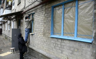 Un homme répare les fenêtres d'un logement le 13 novembre 2014 à Donetsk