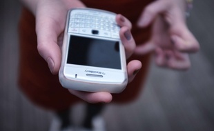 Une femme consulte sa messagerie électronique sur son smartphone.