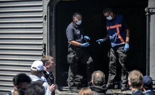 Des membres de l'OSCE devant les wagons où se trouvent les corps des victimes du crash le 21 juillet 2014 à Torez