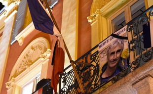 The image of mountain-guide Herve Gourdel, is placed on the balcony of the town hall on September 24, 2014, in Saint-Martin-Vésubie, following his beheading by Jihadists linked to the Islamic State group in Algeria. Jund al-Khilifa, or "Soldiers of the Caliphate," beheaded the 55-year-old Frenchman who was abducted on September 21 while hiking in a national park that was once a magnet for tourists but later became a sanctuary for Islamists. AFP PHOTO / ANNE-CHRISTINE POUJOULAT