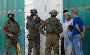 Des soldats israéliens interrogent des Palestiniens le 17 juin à Hebron, dans le cadre de l'enquête pour rechercher trois jeunes israéliens disparus depuis 6 jours