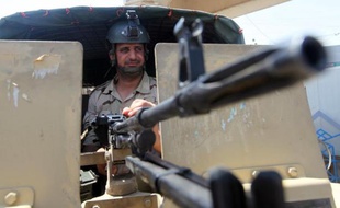 Un membre des forces de sécurité irakiennes garde un poste à Bagdad le 17 août 2014
