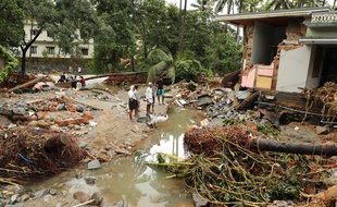 Des habitants observent les dégâts causés par les crues à Kannappankundu, dans l'Etat du Kerala, vendredi 10 août.