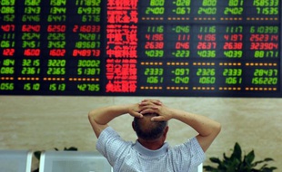 Un investisseur chinois scrute un tableau électronique avec les cours de la bourse de Shanghaï, le 19 juin 2015