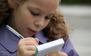 Une petite fille qui fait ses devoirs;