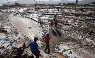 Des habitants cheminent sur une route inondée à Diego de Almagro, à 1.000 km au nord de Santiago du Chili, le 29 mars 2015.