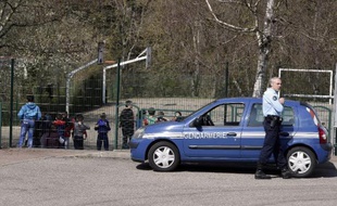 Des gendarmes devant l'école de Villefontaine où exerçait le directeur d'école soupçonné de viols le 24 mars 2015