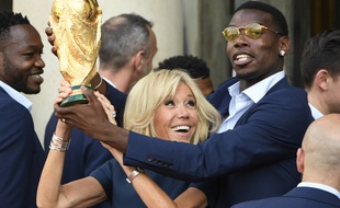 Brigitte Macron et Paul Pogba soulèvent la Coupe du monde de football, le 16 juillet 2018 à l'Elysée.