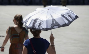 Une femme se protège du soleil à Paris, le 30 juin 2015