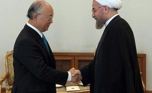 Photo fournie par la présidence iranienne montrant le président iranien Hassan Rohani (d) serrant la main du patron de l'Agence internationale de l'énergie atomique (AIEA,)Yukiya Amano, le 17 aoput 2014 à Téhéran