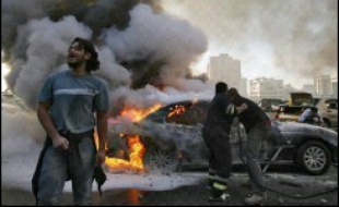 Des Libanais tentent d'éteindre une voiture incendiée, le 25 janvier 2007 à Beyrouth, théâtre d'affrontements depuis plusieurs jours