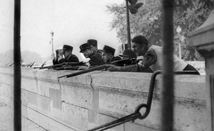 Photo prise en août 1944 de policiers et d'un membre des FFI (Forces Françaises de l'Intérieur) surveillant les quais de la Seine, près de la préfecture lors de la libération de Paris.