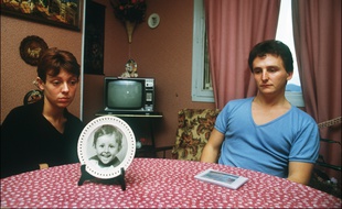 Christine et Jean-Marie Villemin, les parents du petit Grégory, 4 ans, retrouvé noyé le 16 octobre 1984, pieds et poings liés dans la Vologne, sont assis, le 23 novembre 1984, autour de la table de leur salle-à-manger sur laquelle est posée une assiette à l'effigie de leur enfant.
