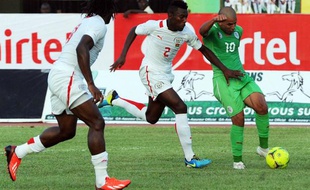 Le joueur algérien Sofiane Faghouli (à droite) lutte pour le ballon avec le joueur burkinabé Steeve Yago lors d'un match opposant leurs deux pays le 12 octobre 2013 à Ouagadougou.