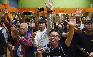Des soutiens d'un candidat pro-démocratie célèbrent leur victoire, à Hong Kong, dans la matinée du 25 novembre 2019.