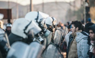 Migrants et réfugiés face-à-face avec la police grecque qui leur interdit de passer la frontière avec la Macédoine, le 3 décembre 2015, à Idomeni, en Grèce
