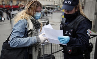 Une policière contrôle une passante devant le gare Montparnasse à Paris, le 21 mars 2020.