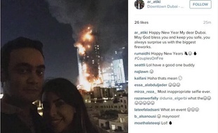 Le couple prend la pose devant l'hôtel cinq étoiles ayant pris feu le soir du 31 décembre 2015, à Dubaï.