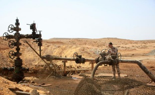 Un membre des forces syriennes près d'un puit de pétrole à proximité de Palmyre, en Syrie, après que la région a été reprise au groupe EI, le 9 mars 2015