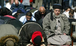 Le prêcheur islamiste britannique Abou Hamza (d) lors de la prière le 2 Avril 2004 à Londres