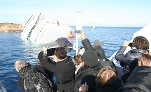 Des journalistes photographient l'épave du Costa Concordia, le 20 janvier 2012.