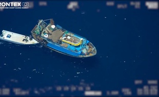Le bateau, suivi d'un canot de fortune où sont débarqués les migrants.