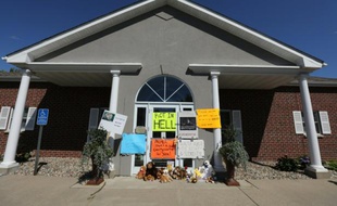 Des animaux en peluche et des affiches envoyant Walter Palmer "rôtir en enfer" pour la mort du lion Cecil sont déposés le 29 juillet 2015 devant la clinique du dentiste à Bloomington, dans le Minnesota