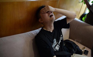 Un proche d'une victime du naufrage d'un navire de croisière sur le Yangtsé bouleversé par la nouvelle, près d'une agence de voyage à Shanghai, le 2 juin 2015