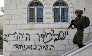 Un soldat israélien marche devant une maison à Ramallah le 5 mars 2015