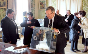 Le garde des Sceaux et président centriste sortant du conseil général du Rhône, Michel Mercier regarde une urne le 20 mars 2011, au bureau de vote à Thizy (Rhône) pour les élections cantonales, où il est candidat et conseiller depuis 1978. Quelque 21,4 millions d'électeurs sont appelés à désigner aux cantonales, 2.026 conseillers généraux qui siègeront jusqu'en 2014, date à laquelle ils seront remplacés par les conseillers territoriaux. Il s'agit du dernier scrutin au suffrage universel avant la présidentielle de 2012.