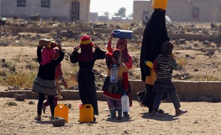 Une femme yéménite et ses enfants portent des jerrycans d'eau à Sanaa, le 14 novembre 2016.