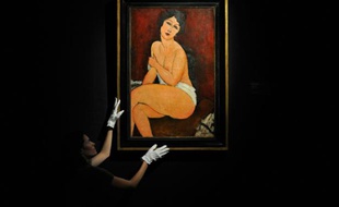 Une employée tient une peinture de 1917, intitulée "la belle Romaine", de Modigliani, chez Sotheby's à Londres le 11 octobre 2010