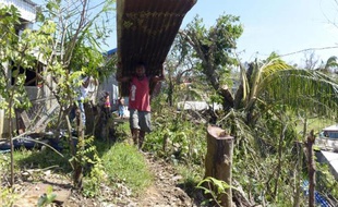 Un homme nettoie les débris laissés par le cyclone Pam à Port-Vila sur l'île du Vanuatu le 17 mars 2015